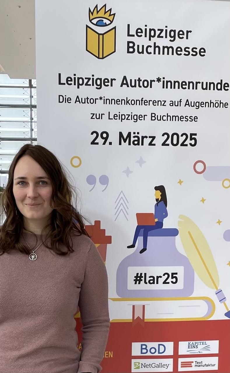 Foto der Autorin vor einem Plakat der Leipziger Autor:innenrunde